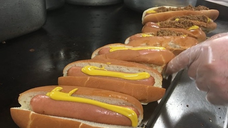 hand pointing to hot dogs on grill at Hot Dog World in North Carolina