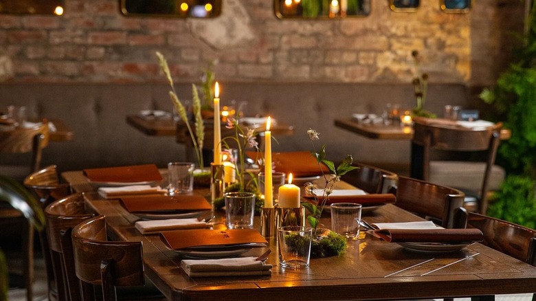 A table is set at Compere Lapin with candles and wooden accents