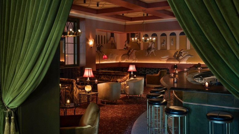 The lavish interiors of Il Premio are framed by green velvet curtains