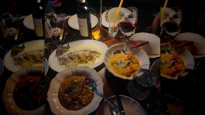 Plates of pasta with wine on table