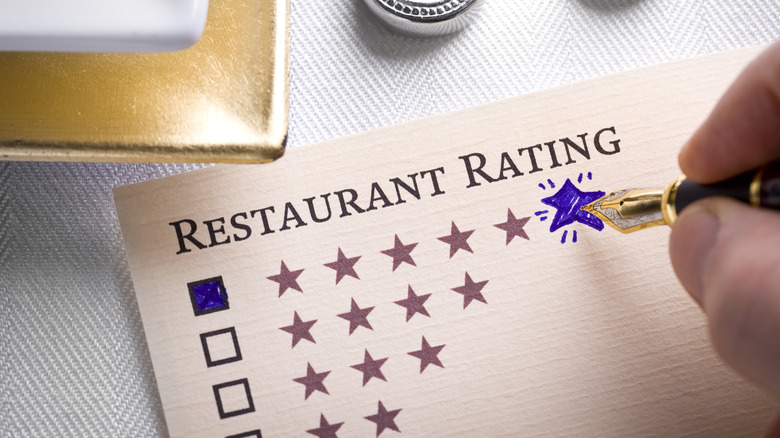 Restaurant Rating concept with pen and table setting.