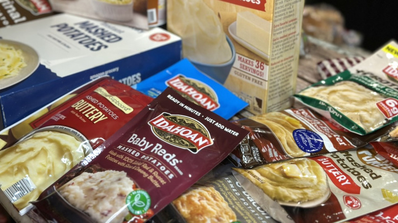 Assorted instant mashed potato packages on table.