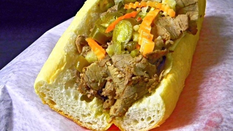 An Italian beef sandwich sitting on a sandwich wrapper.