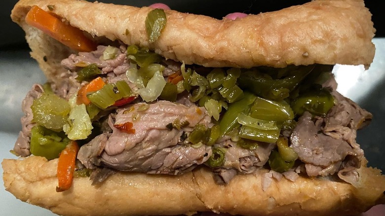 An Italian beef sandwich held on its side.