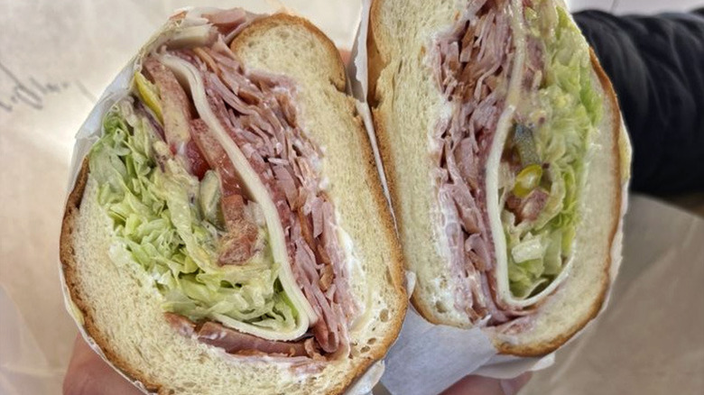 Person holding Ocean Subs original Italian sub cut in half