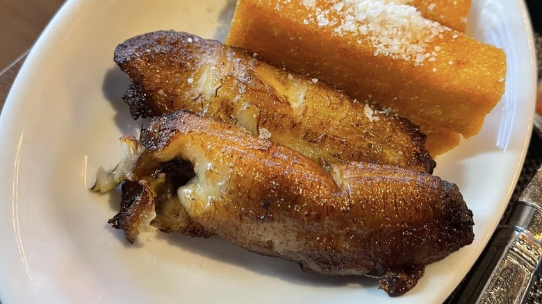 Two caramelized bananas on a white plate.