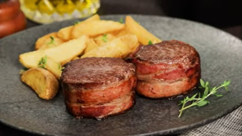 Morsel of bacon wrapped steak on plate.