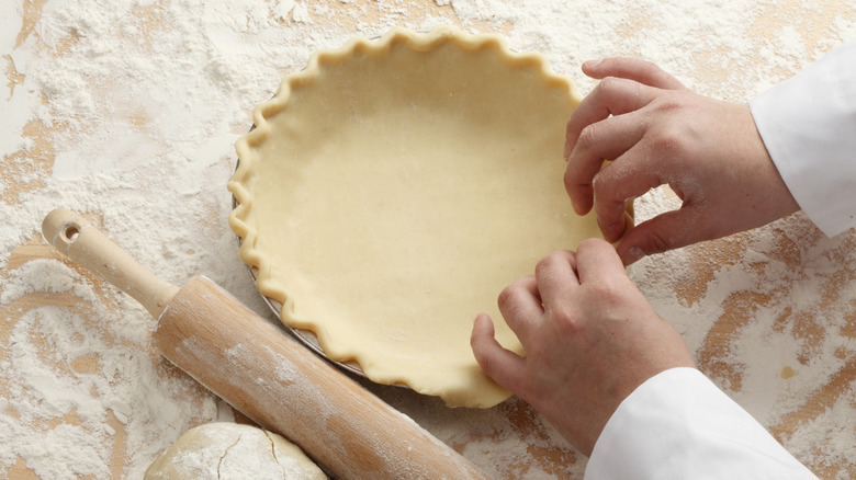 A person shaping some pie dough.