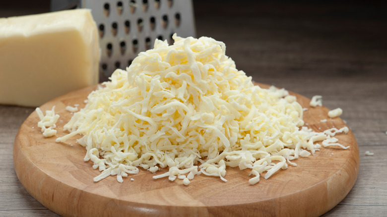 Shredded mozzarella on wooden board