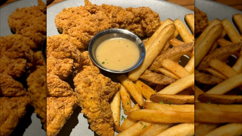 Outback chicken tenders and fries with a pot of sauce