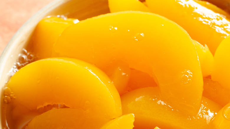 Closeup of canned peach slices in bowl