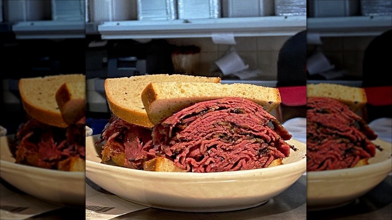 Open face stuffed pastrami sandwich on white plate