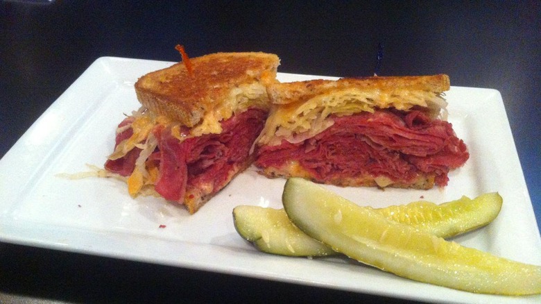 Plated cut pastrami sandwich with pickles