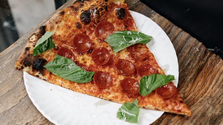 Close up of pepperoni and basil slice
