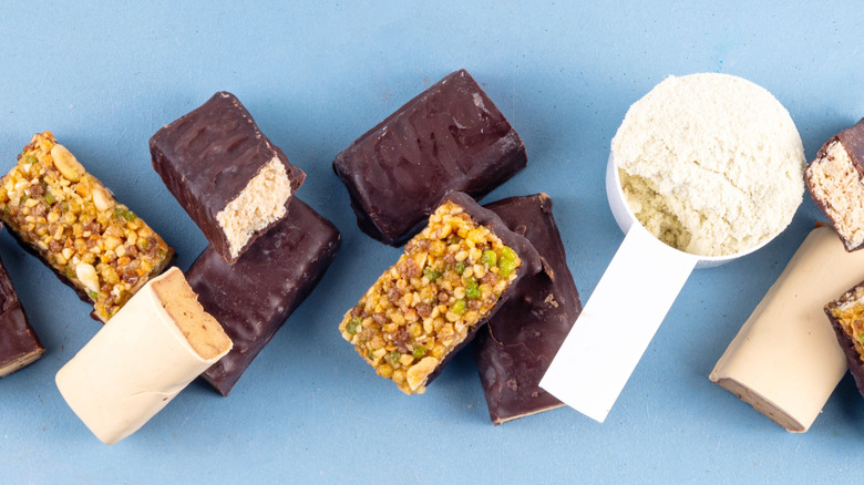 Assorted protein bars and scoop of protein powder