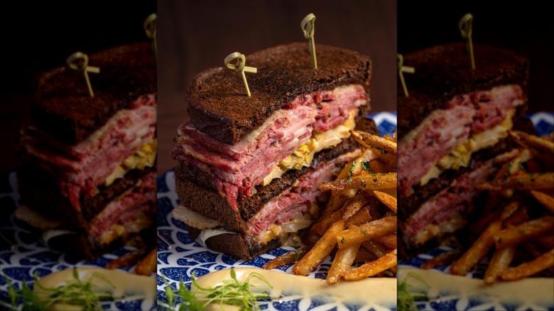 A Rueben cut in half on a play with fries