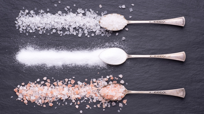 different kinds of salt spread out on a dark background