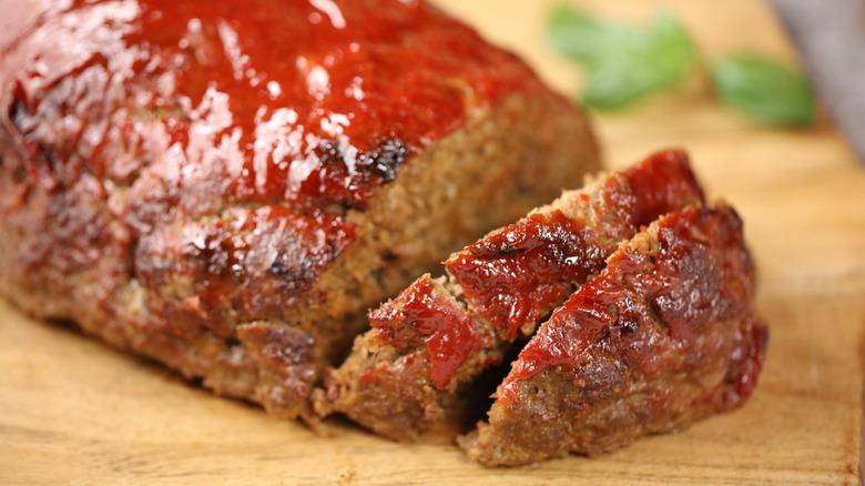 ketchup-covered meatloaf on a wooden board