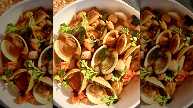 Bowl of clams in a broth in white bowl
