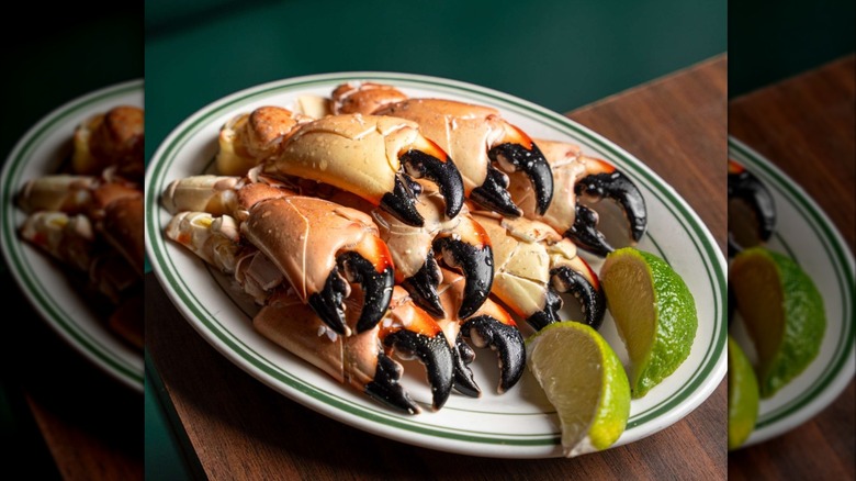 White plate of several stone crab claws with lime on side