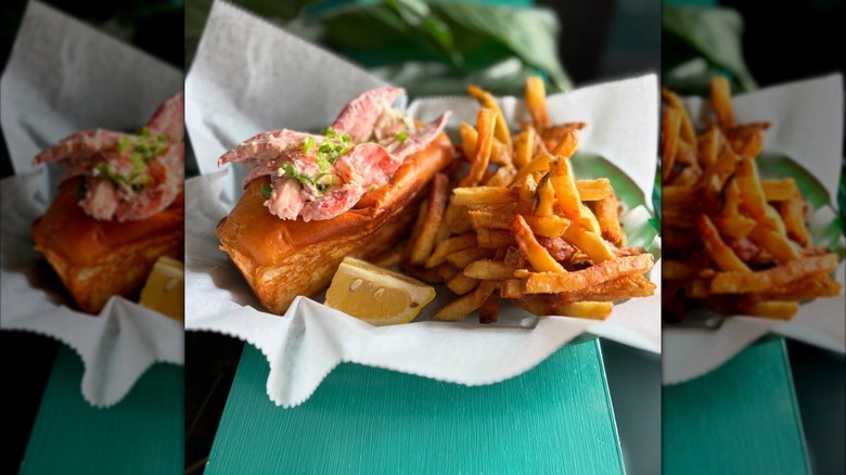 Lobster roll with side of fries in paper-lined basket