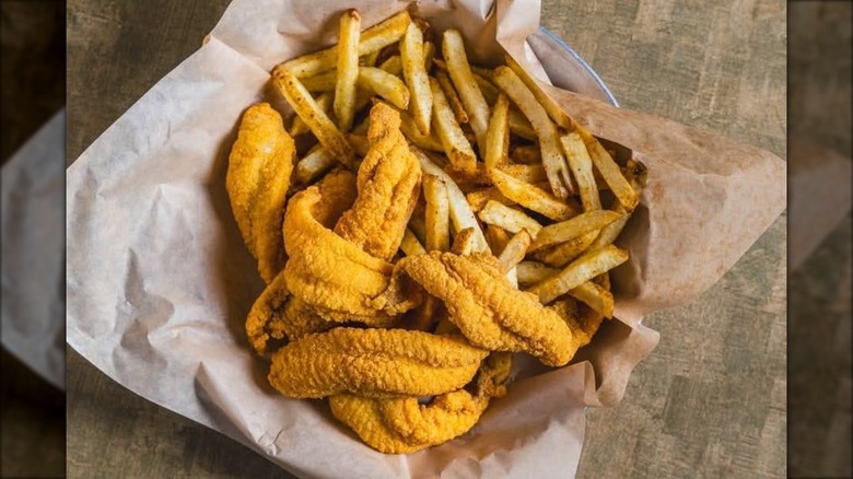 Basket of fried catfish with a side of fries