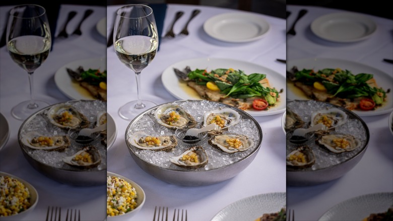 Topped oysters on ice filled serving plate
