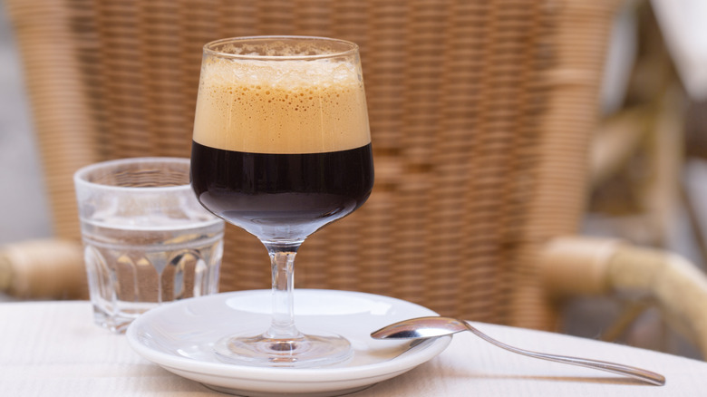 A traditional Italian shakerato in a glass on a plate.