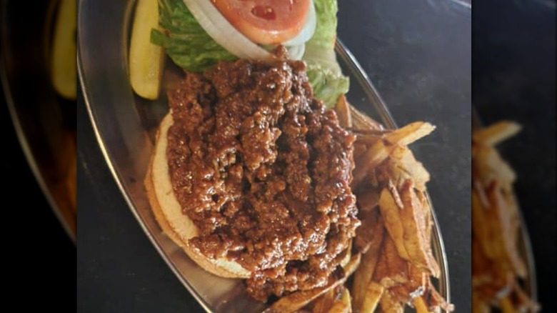 Moody's Pub open face sloppy joe with lettuce, tomato, onion, and fries on metal tray