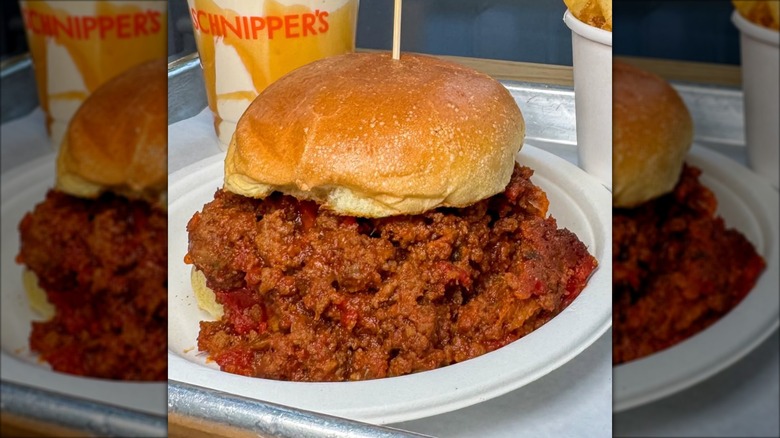 schnippers overflowing sloppy joe on white bun on white plate