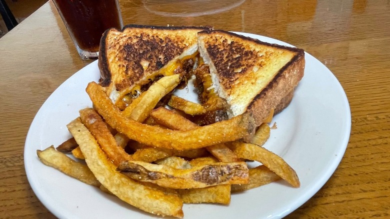 Zaharakos' Sloppy Joe sandwich on toasted bread slices and cheese with side of fries on white plate