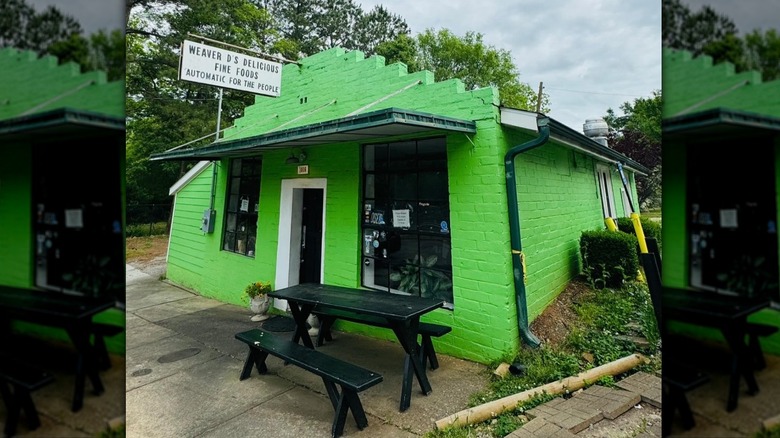 Weaver D's Delicious Fine Foods exterior bright green building with black picnic table in front