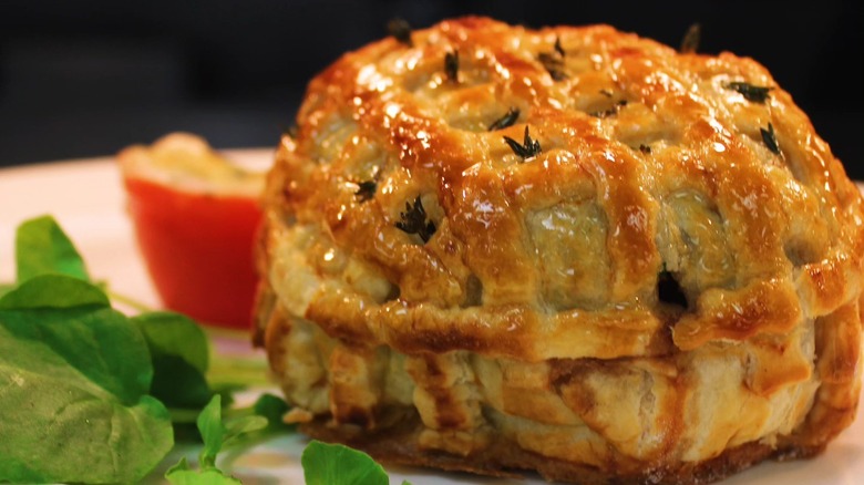 Beef Wellington with garnish on a white plate