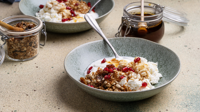 Bowl of cottage cheese with honey, pomegranante, granola