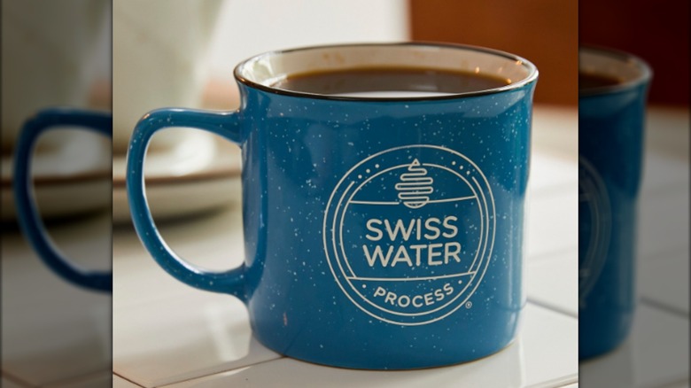 A blue coffee mug labeled "Swiss Water Process"