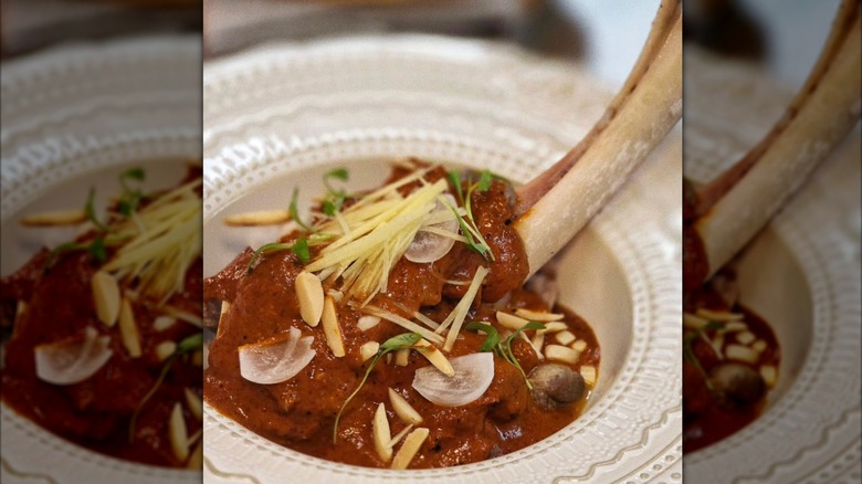 Lamb shank dish with Javanese curry topped with ginger, pickled shallots, toasted almonds at Saam restaurant