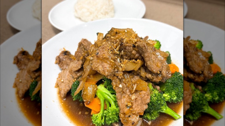 Thai dish with broccoli, carrots, and sliced beef in broth next to rice pilaf at Thai Diner Fort Wayne