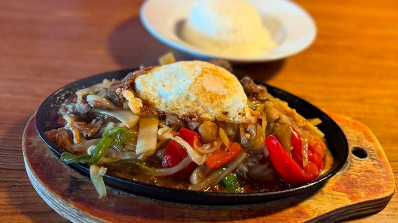 Thai Stir Fry skillet topped with a fried egg at Pho Thai