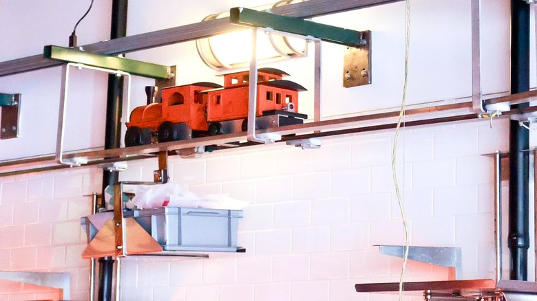 All Aboard Restaurant and Grill interior decor with model trains running on tracks overhead