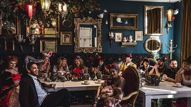 Interior Alice in Wonderland themed dining room with patrons dressed up like a Mad Hatter party tea