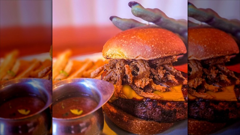 Monster Vegan burger with a Zombie-like hand in background