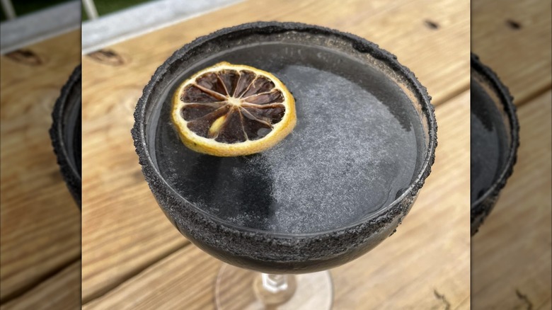 A black cocktail on the table at Betelgeuse Betelgeuse restaurant
