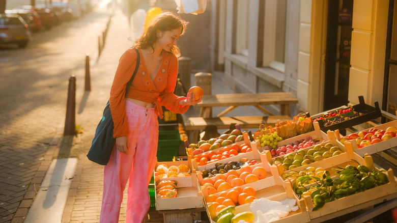 woman picks out produce in the rising sun
