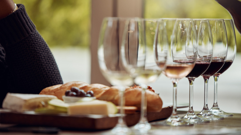 Wine tasting set up with different wines in glasses and a charcuterie platter,