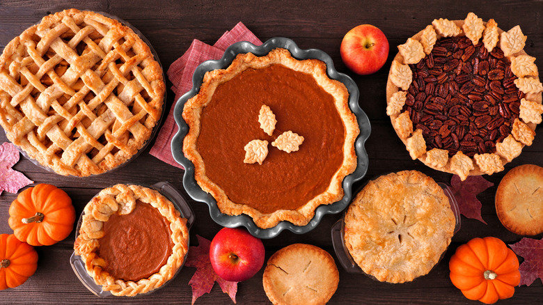 Assortment of pies with fall decorations on a wooden surface