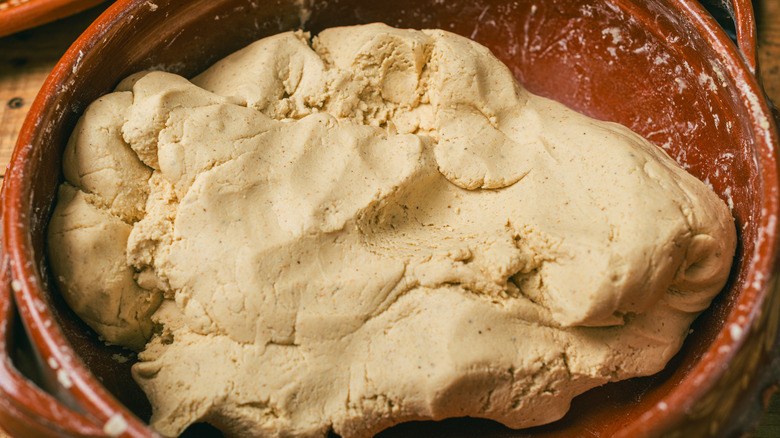 Nixtamalized corn masa dough in a clay bowl. Typical Mexican food to make homemade tortillas