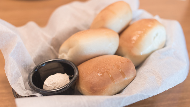 Texas Roadhouse rolls with cinnamon honey butter in a basket.