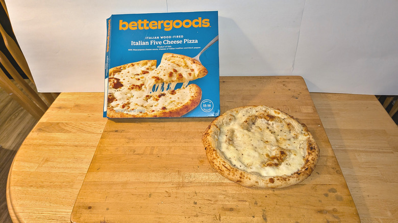 Bettergoods Italian Five Cheese Pizza cooked on cutting board next to package.