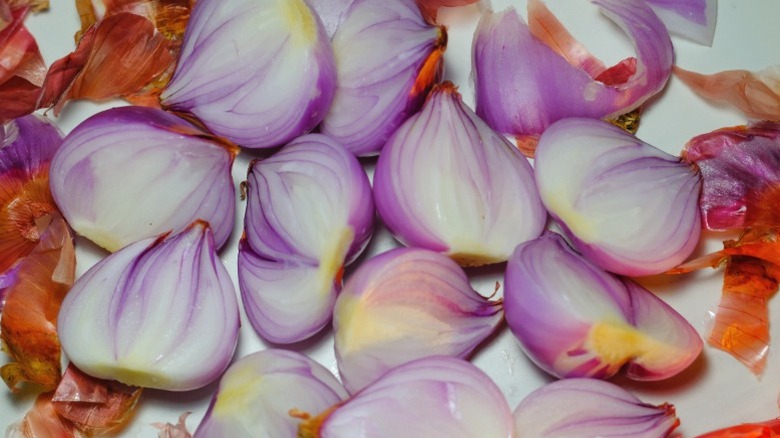Peeled shallots framed by discarded shallot peels