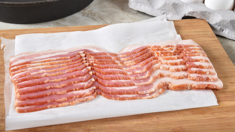 Uncooked bacon on cutting board